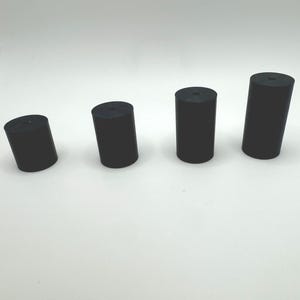 May include: Four black rubber cylindrical stoppers of varying sizes.