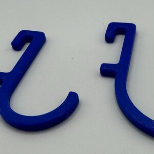 Puede incluir: Tres ganchos de pl&aacute;stico azul de diferentes tama&ntilde;os. Los ganchos tienen forma de 'J' y est&aacute;n dise&ntilde;ados para colgar objetos.