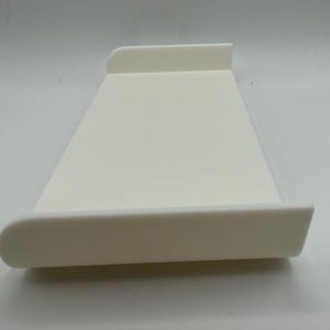 May include: A white plastic tray with rounded edges. The tray is designed to be used as a laptop stand.