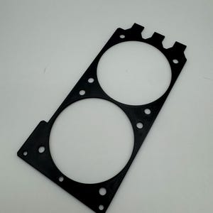 May include: Black plastic fan mount with two circular cutouts for fans. The mount has multiple holes around the edges for mounting screws.