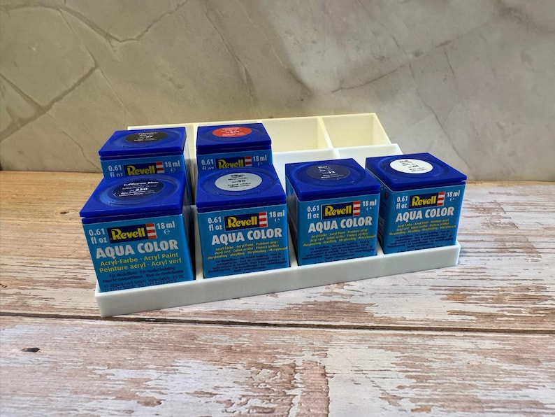 Peut inclure: Ensemble de peintures acryliques Revell Aqua Color en pots bleus carr&eacute;s, chacun contenant 18 ml. Les pots sont dispos&eacute;s dans un organisateur en plastique blanc. Id&eacute;al pour la peinture de maquettes.