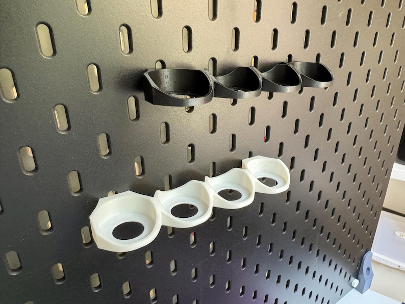 Puede incluir: Un conjunto de seis organizadores de pared de pl&aacute;stico blanco y negro. Los organizadores est&aacute;n dise&ntilde;ados para contener art&iacute;culos peque&ntilde;os como herramientas o accesorios.