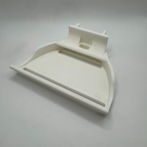 May include: A white, 3D-printed scoop-shaped object with a handle and a raised back. The scoop has a curved front and a rectangular opening in the back. The object is made of a solid, opaque material.
