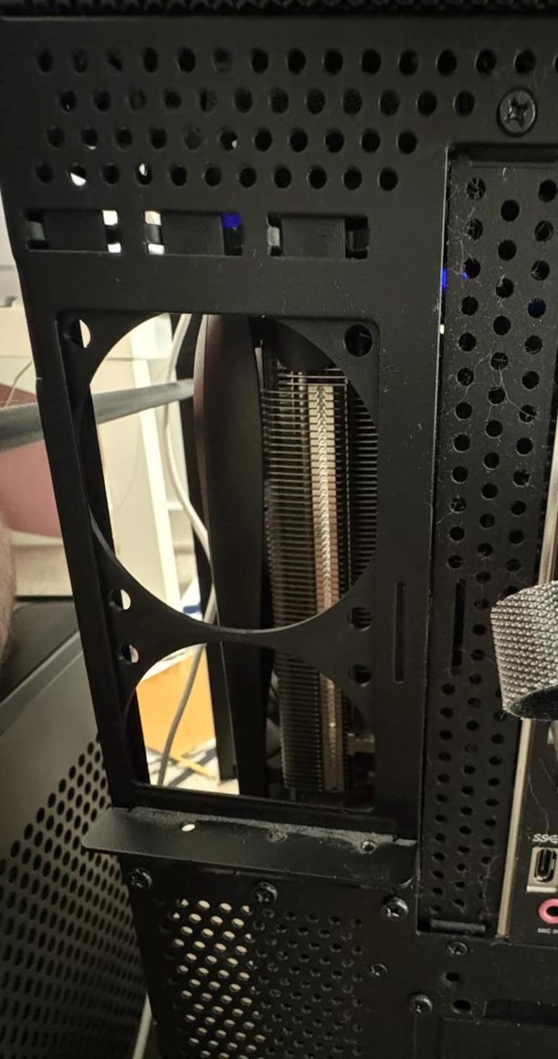 Peut inclure: Un bo&icirc;tier d'ordinateur noir avec un panneau en maille m&eacute;tallique et un support de ventilateur noir. Le support de ventilateur a deux ouvertures circulaires pour les ventilateurs. Le bo&icirc;tier a une sangle en m&eacute;tal noir sur le c&ocirc;t&eacute; droit.