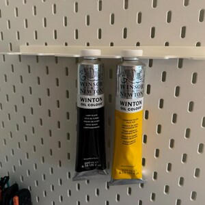 May include: Two tubes of Winsor & Newton Winton Oil Colour paint. One tube is black, labeled "Lamp Black", and the other is yellow, labeled "Cadmium Yellow Pale Hue". Each tube contains 200 ml or 6.76 US fl oz of paint.