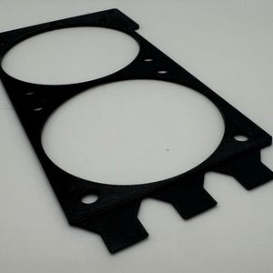 Peut inclure: Support de ventilateur en plastique noir avec deux d&eacute;coupes circulaires pour les ventilateurs. Le support comporte une s&eacute;rie de languettes le long du bord inf&eacute;rieur.