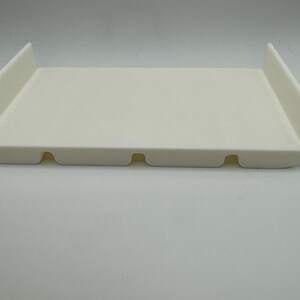 May include: White plastic tray with rounded edges and three small holes in the bottom.
