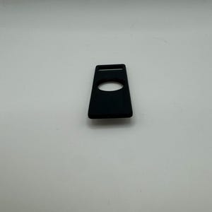 Pu&ograve; includere: Una custodia in silicone nero per un piccolo dispositivo elettronico, come un lettore musicale portatile o un tracker di fitness. La custodia ha un ritaglio per un pulsante o uno schermo.
