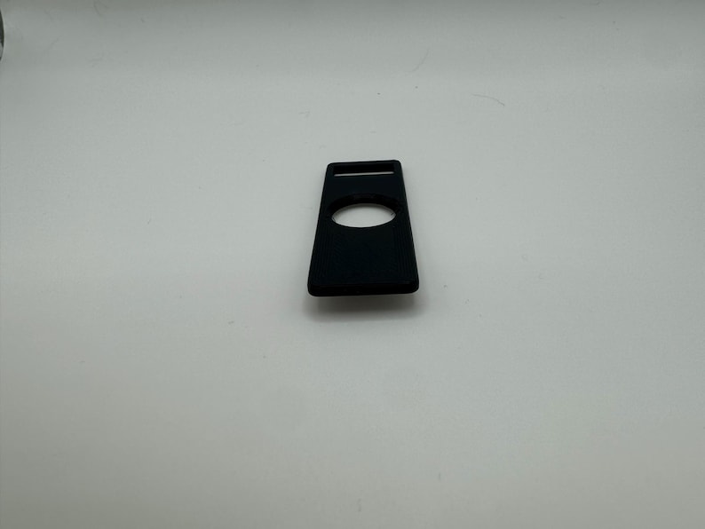 Pu&ograve; includere: Una custodia in silicone nero per un piccolo dispositivo elettronico, come un lettore musicale portatile o un tracker di fitness. La custodia ha un ritaglio per un pulsante o uno schermo.