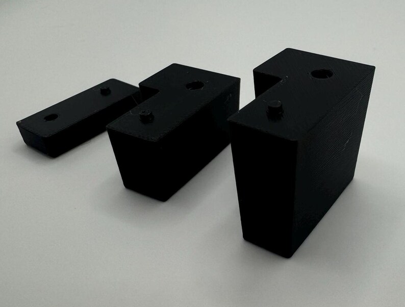 May include: Three black plastic corner brackets, two are L-shaped and one is a straight piece.