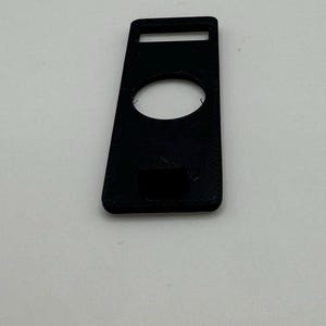 Pu&ograve; includere: Custodia in plastica nera con un ritaglio per un dispositivo. La custodia ha una piccola apertura rettangolare nella parte superiore.