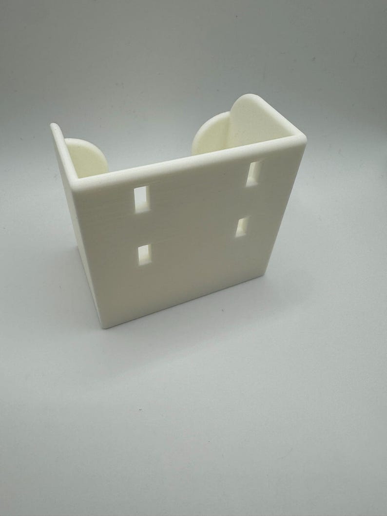 May include: A white, rectangular bracket with four evenly spaced rectangular holes. The bracket has rounded edges and a curved design on the top. The object is made of a solid, opaque material.