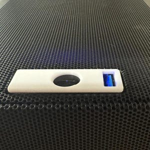 Pu&ograve; includere: Una porta USB bianca su un altoparlante nero con una griglia a rete nera.