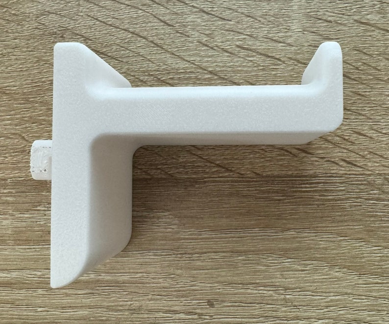 Pu&ograve; includere: Un supporto a parete bianco a forma di L per cuffie. Il supporto ha una superficie strutturata e un piccolo perno laterale per il montaggio. Il design &egrave; semplice e moderno, adatto per organizzare le cuffie.