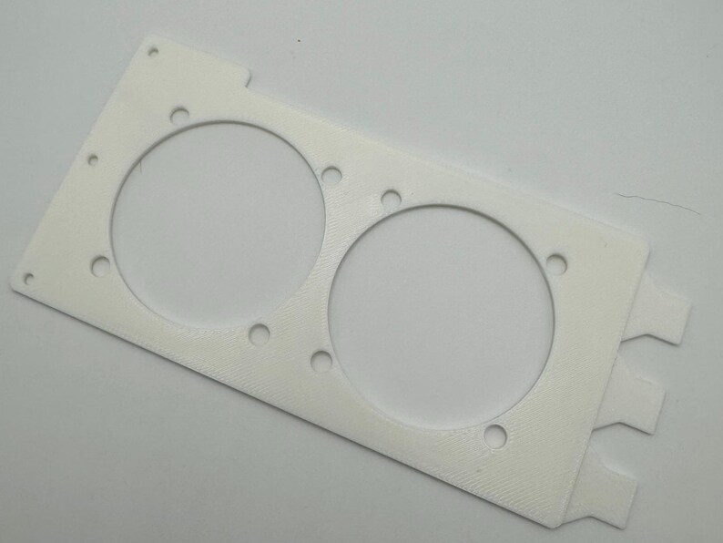 Peut inclure: Support de ventilateur en plastique blanc avec deux d&eacute;coupes circulaires pour les ventilateurs. Le support comporte plusieurs petits trous autour des bords des d&eacute;coupes.