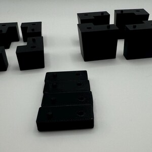 May include: A set of black plastic corner brackets, some are L-shaped and some are straight. There are also five smaller black plastic pieces.