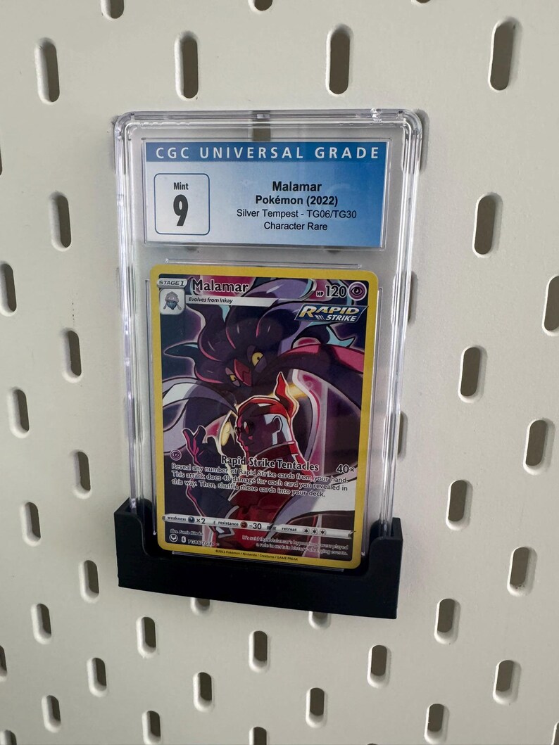 May include: A graded Pokemon card in a clear plastic case. The card is a Malamar from the Silver Tempest set. The card is graded a 9 by CGC, which is considered Mint condition.