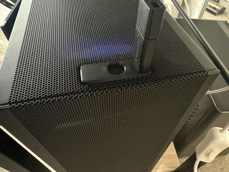 Pu&ograve; includere: Una torre per computer nera con un pannello frontale in rete nera. Un adattatore USB nero &egrave; collegato alla torre.