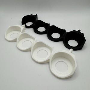 Puede incluir: Dos juegos de tres anillos de pl&aacute;stico negro y blanco, cada juego conectado entre s&iacute;. Los anillos est&aacute;n dise&ntilde;ados para sujetar objetos peque&ntilde;os, como llaves o joyas.
