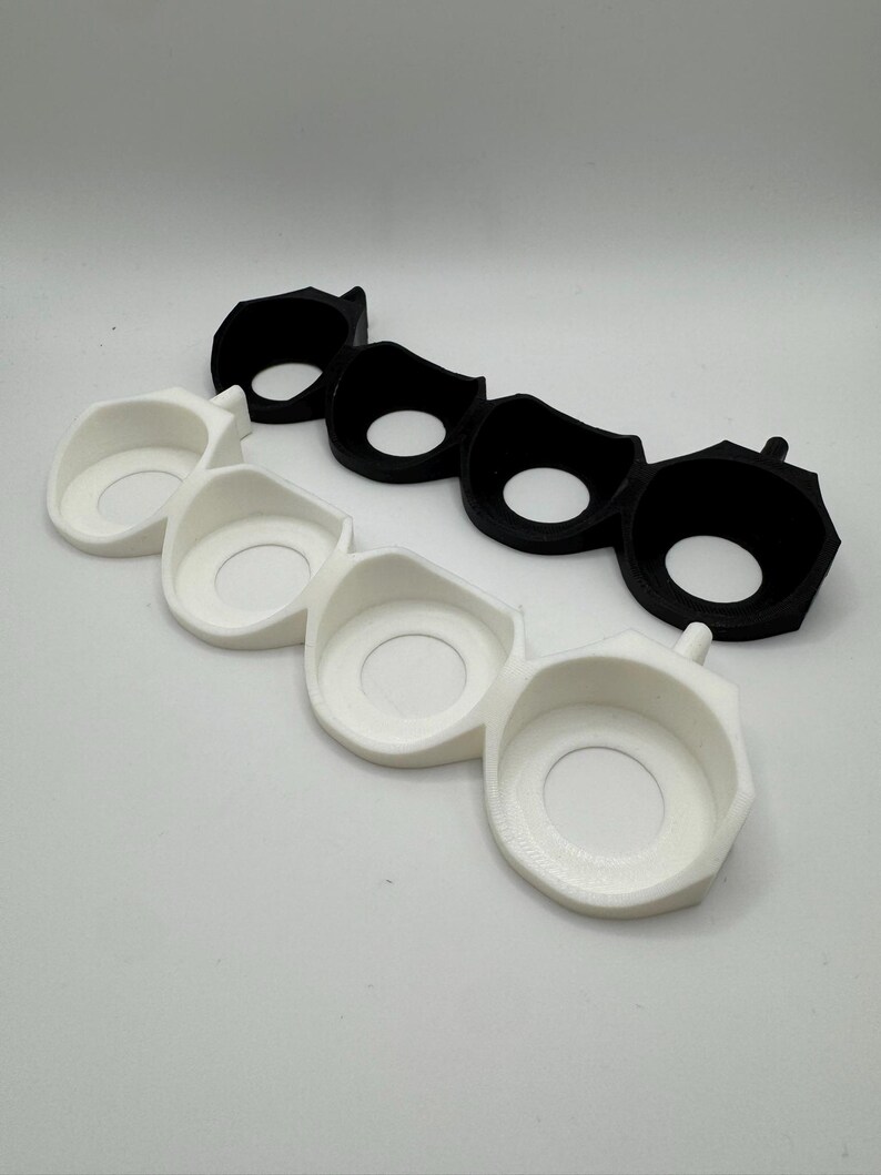 Puede incluir: Dos juegos de tres anillos de pl&aacute;stico negro y blanco, cada juego conectado entre s&iacute;. Los anillos est&aacute;n dise&ntilde;ados para sujetar objetos peque&ntilde;os, como llaves o joyas.