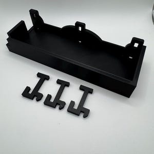 May include: Black plastic 3D printed wall shelf with three black plastic letters that spell "III"