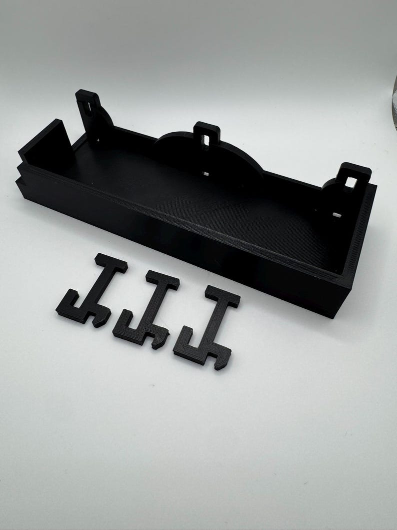 May include: Black plastic 3D printed wall shelf with three black plastic letters that spell "III"
