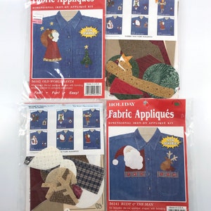 Puede incluir: Dos paquetes de kits de apliques de tela navideños para planchar. Cada kit incluye una camisa de mezclilla azul con un diseño festivo. El primer kit presenta un diseño de Papá Noel con un gorro rojo y un árbol verde. El segundo kit presenta un diseño de Papá Noel con un gorro rojo y un reno. Ambos kits incluyen el texto "¡Ahora cosido!" y "¡Rápido! ¡Divertido! ¡Fácil!"