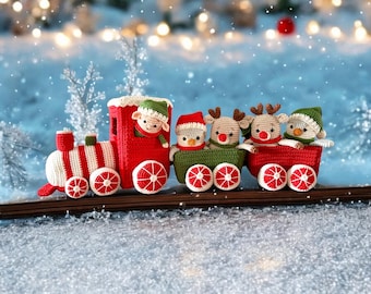 May include: A red toy train with white stripes pulls a string of five crocheted Christmas characters. The characters include a snowman, a reindeer, and three elves. The train is on a snowy surface.