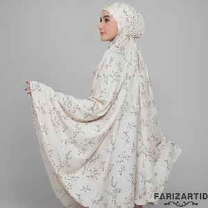 May include: Cream-coloured prayer garment set with a floral pattern. The set includes a head covering and a long, flowing robe. The floral design is in a muted grey colour. The garment is made of a lightweight fabric.