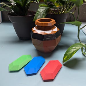 A clay pot with cracks in it, like it can be broken. Three crystal rupees, one red, one green, one blue.