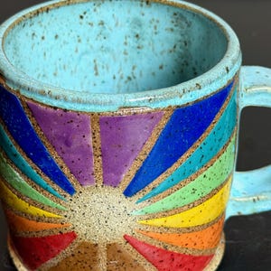 May include: A white ceramic mug with a black handle and the text "But First, Coffee" in a handwritten style. The mug is on a white surface. The mug is 4 inches tall.