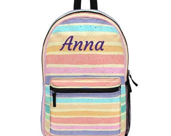 May include: A colorful backpack with horizontal stripes in pastel shades of pink, yellow, blue, and purple. The name "Anna" is printed in a dark purple script across the top. The backpack has a black handle, zipper, and mesh side pocket.