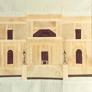 以下が含まれることがあります： ベージュとブラウンのキルトブロックで、湾曲した屋根、両側に2つの窓、湾曲したトップのセントラルエントランスを持つ建物が描かれています。建物には白い手すりがあり、2つの街灯があります。