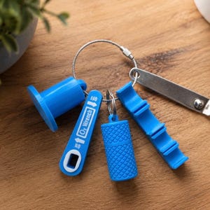 May include: A blue oxygen tank wrench tool set on a metal keyring. The set includes a blue plastic O2 wrench with ON and OFF text, a blue textured cylindrical cap, a blue notched tool, and a flat silver metal bottle opener attachment.