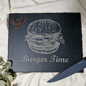 Könnte beinhalten: Schwarzes Schiefer-Servierbrett mit einem weißen, gravierten Bild eines Hamburgers und dem Text "Burger Time".