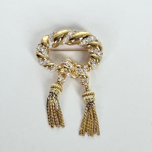 Broche vintage de Kenneth Jay Lane KJL con diamantes de imitación, lazo retorcido y borlas