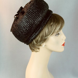 May include: A black straw hat with a rounded crown and a wide brim. The hat is made of a woven material and has a simple design.