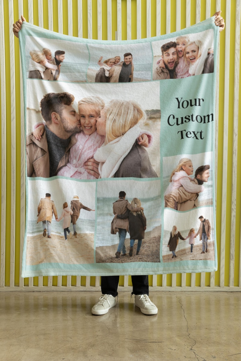 Op de afbeelding: Een lichtblauwe fleece deken met een collage van familiefoto's. De foto's tonen een gezin van vier op het strand, een stel dat een kind vasthoudt en een groep mensen die lachen. De tekst "Your Custom Text" is op de deken gedrukt.