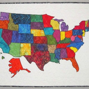 May include: A colorful patchwork quilt depicting the United States of America. Each state is represented by a different fabric pattern and color.