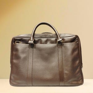 May include: A brown leather briefcase with a top handle and a zippered closure.