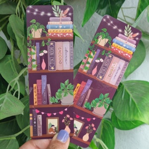 May include: Two purple bookmark designs featuring illustrations of bookshelves, plants, and fairy lights. The text on the bookmarks reads "Moon Cycle", "Dream", "luna", "4", "Summer Dreams", and "Love Story".