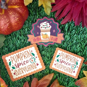 Op de afbeelding: Drie herfst-thema stickers met een ontwerp van een pumpkin spice latte. De eerste sticker zegt "Hello Fall" met een pumpkin spice latte en een pompoen. De tweede en derde stickers zeggen "Pumpkin Spice Everything" met een kopje koffie en harten.