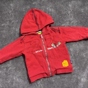 Könnte beinhalten: Rustikales Holzschild mit dem weißen Schriftzug "Welcome to our home". Das Schild hat eine Used-Optik und ein schlichtes, einladendes Design, perfekt für Veranda oder Eingangsbereich.