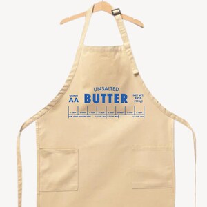 May include: A beige apron with blue text that reads "UNSALTED BUTTER." The apron has a measurement guide for butter, including 1/4 cup and 1/3 cup. The net weight is 4 oz (113g).
