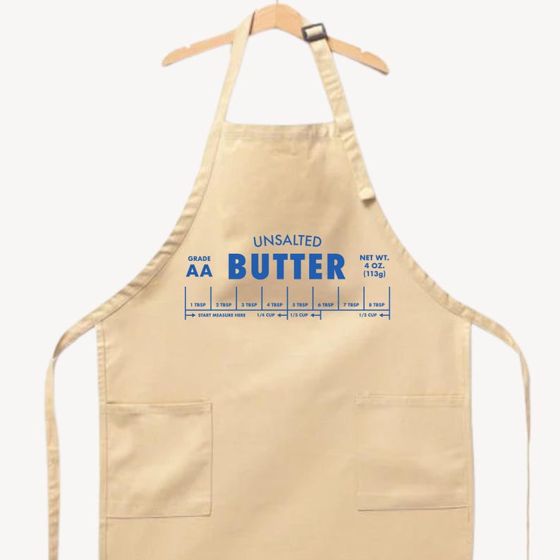 May include: A beige apron with blue text that reads "UNSALTED BUTTER." The apron has a measurement guide for butter, including 1/4 cup and 1/3 cup. The net weight is 4 oz (113g).