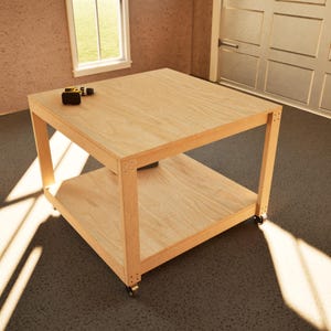 May include: A light-coloured wooden workbench with a lower shelf and castors. A cordless drill and battery are on the top surface. The workbench is square and appears to be made of plywood. The workbench is in a garage setting.
