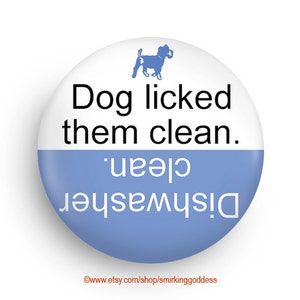 May include: A blue and white round button with a black silhouette of a dog and the text "Dog licked them clean. Dishwasher 'clean'"
