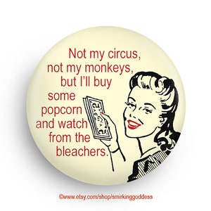 May include: A vintage-style button with a woman holding money and the text "Not my circus, not my monkeys, but I'll buy some popcorn and watch from the bleachers."