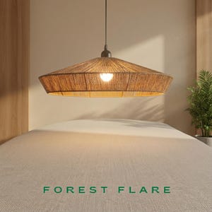 May include: A woven, brown pendant light fixture with a wide, conical shade hangs above a bed. The light is on, illuminating the interior of the shade. The text "FOREST FLARE" is at the bottom of the image.