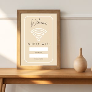 Puede incluir: Un cartel enmarcado con fondo beige y un símbolo wifi blanco. El cartel dice "Bienvenido" y "WIFI DE INVITADOS" con espacios en blanco para el nombre de la red y la contraseña.